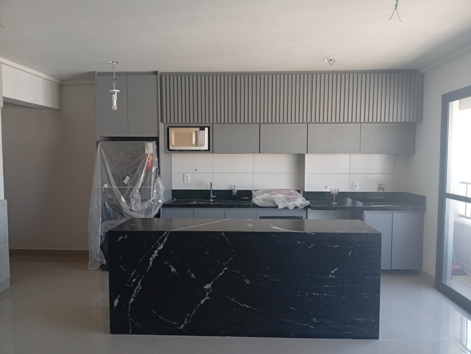 Cozinha planejada cinza em fase de instalacao